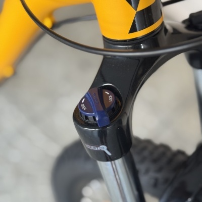 Bicicleta amarela com suspensão GS20 e controle azul de bloqueio na frente