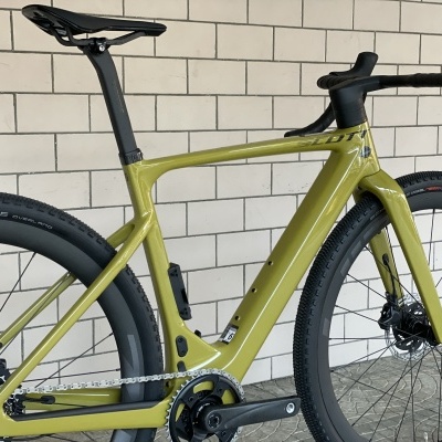 Bicicleta de estrada elétrica verde-oliva com quadro em carbono e rodas de perfil alto