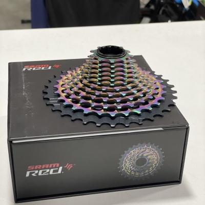 Cassete de bicicleta multicolorida sobre caixa preta com texto SRAM RED.