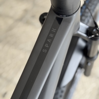 Bicicleta preta com o nome SPARK no quadro superior e pneus robustos