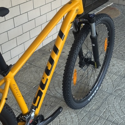 Bicicleta de montanha amarela com pneus pretos e detalhes laranja