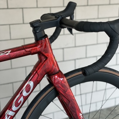 Bicicleta de estrada Colnago vermelho metalizado com guiador curvo preto e pneu castanho claro
