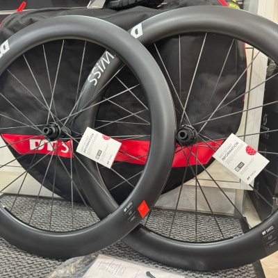 Rodas de bicicleta de estrada pretas com etiquetas penduradas em ambiente de loja