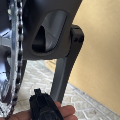 Pedal preto removível de bicicleta perto da corrente e caixa de cartão