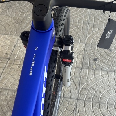 Bicicleta de montanha azul com guiador preto vista de cima e chão de azulejos cinzentos