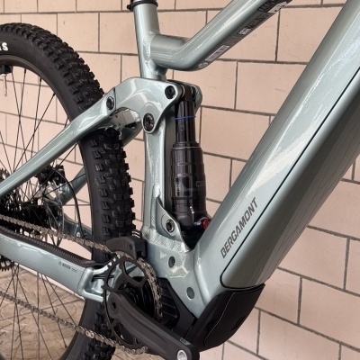 Bicicleta de montanha cinzento claro com suspensão traseira preta e pneus de terreno acidentado