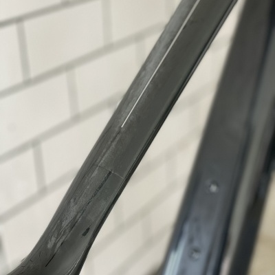 Estrutura preta de bicicleta com fundo de azulejos brancos