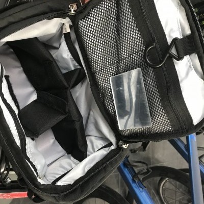 Bolsa para ciclista com interior branco e preto, bolsos e divisórias, sobre bicicleta