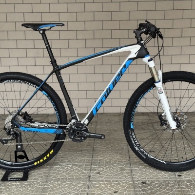 Bicicleta de montanha azul, preta e branca com quadro de carbono e suspensão dianteira