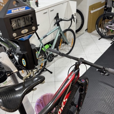 Loja de bicicletas com duas bicicletas, armários brancos e várias caixas no fundo