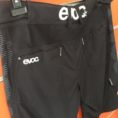 Calções pretos desportivos com logos evoc e estrela brancos