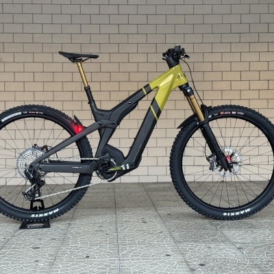 Bicicleta elétrica de montanha preto e verde com suspensão frente ouro