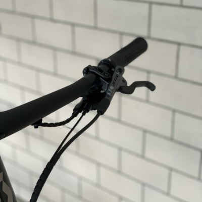 Manete e punho de travão para bicicleta preto com cabo e fundo de azulejos brancos