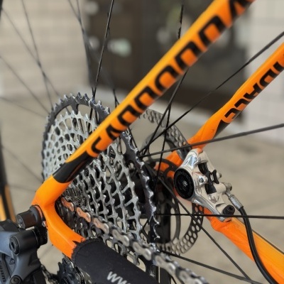 Roda traseira de bicicleta Cannondale laranja com cassete metálico e corrente