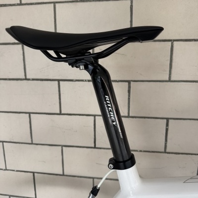 Selim preto com canote em carbono preto e quadro branco de bicicleta