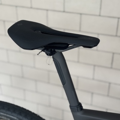 Selim preto de bicicleta com recorte central e canote em carbono