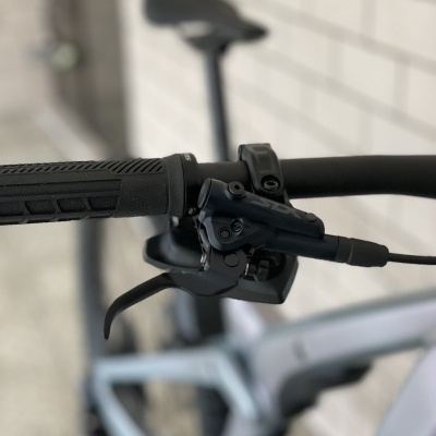 Punho, manete de travão e mudanças de bicicleta preta junto a parede cinzenta