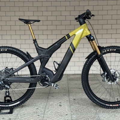 Bicicleta elétrica de montanha com quadro preto e amarelo em suporte