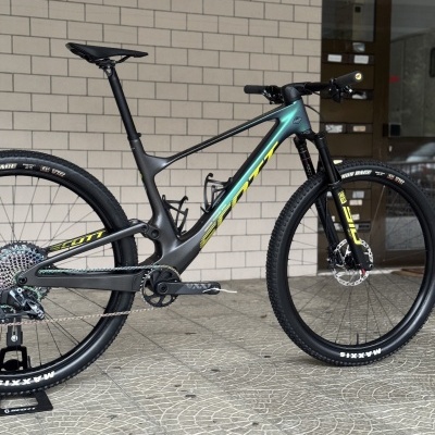 Bicicleta de montanha Scott de carbono preto e verde, pneus Maxxis, suspensão dianteira, transmissão colorida.