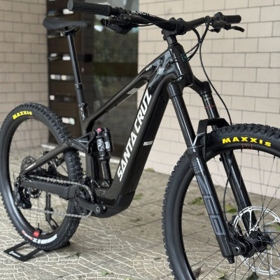 Bicicleta de montanha elétrica preta Santa Cruz com suspensão e pneus Maxxis