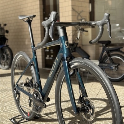 Bicicleta de estrada azul escuro Scott com pneus finos e guiador curvo