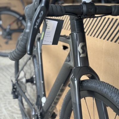 Bicicleta Scott de estrada cinza com guiador preto e travões GRX