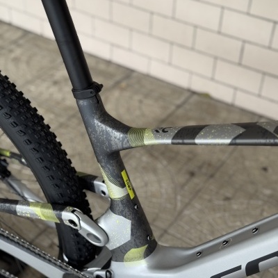 quadro de bicicleta de montanha cinza com padrões verdes e pretos e roda traseira