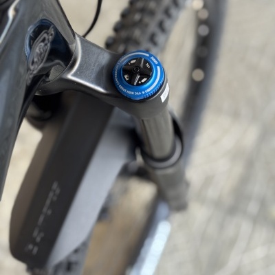 Suspensão dianteira de bicicleta com componente azul e pneus em foco