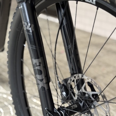 Roda de bicicleta preta com aro DT SWISS e suspensão FOX 34 Performance.