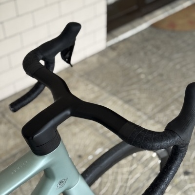 Guidão de bicicleta de estrada preto com quadro verde água e texto ADDICT