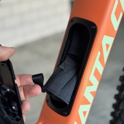 Estrutura de bicicleta laranja com texto branco e compartimento interno preto aberto