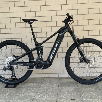 Bicicleta de montanha elétrica preta SCOTT contra parede de azulejos