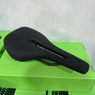 Selim de bicicleta preto TOFINO com recorte central sobre caixa verde