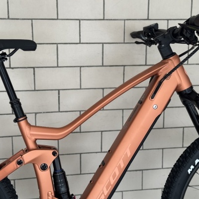 Bicicleta de montanha eléctrica SCOTT bronze com pneus Maxxis e parede tijolos clara