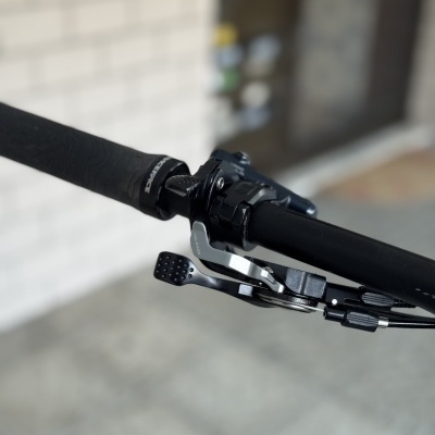 Punho de bicicleta preto com manete metálico prateado e alavanca preta