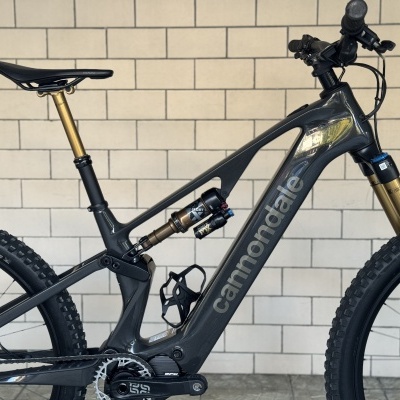 Bicicleta de montanha elétrica Cannondale cinza escuro com suspensão dourada