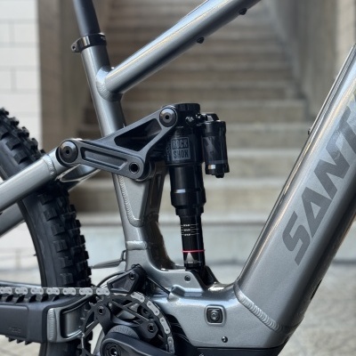 Bicicleta Santa Cruz cinza com suspensão RockShox e pedaleira preta junto a escadas de cimento