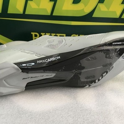 Sola de sapatilha de ciclismo cinza clara e preta em carbono HMX sobre tecido branco