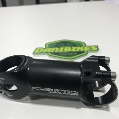 Suporte de guiador de bicicleta preto com texto 'POWER ATTACK LOCKING FACTORY' e logótipo 'DANIBIKES BIKE SHOP' ao fundo