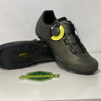 Sapatilhas de ciclismo verdes com sola preta e sistema de fecho por disco em fundo branco.