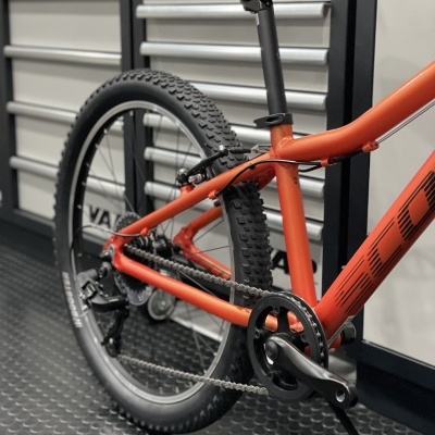 Bicicleta de montanha laranja com pneus grossos e espaço interno