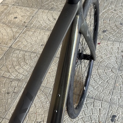 Bicicleta desportiva cinzenta em carbono vista de cima com guiador e roda preto