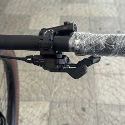 Peças de bicicleta preta com punho envolvido em plástico e etiquetas Shimano