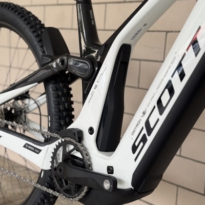 Quadro de bicicleta de montanha preto e branco com pedaleira e pneu visíveis
