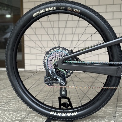 Roda traseira de bicicleta com pneu preto Maxxis Rekon Race em suporte preto