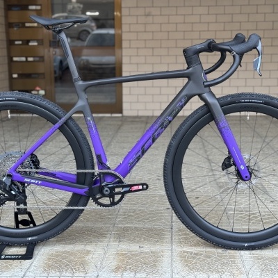 Bicicleta de estrada carbono preto roxo com pneus Schwalbe One RX em exposição