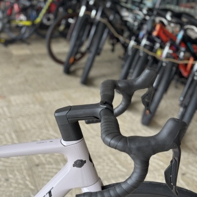 Bicicleta de estrada branca com guiador preto em loja de bicicletas