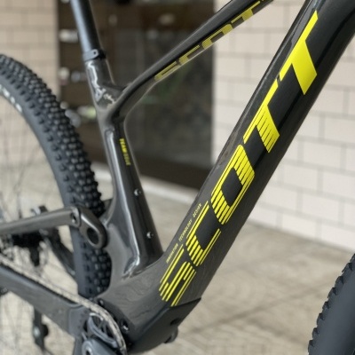 Quadro de bicicleta de montanha SCOTT cinza escuro com logótipo amarelo, pneus de cravos e pedaleira cinza