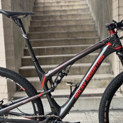 Bicicleta de montanha cinzenta e vermelha com suspensão e pneus de terra