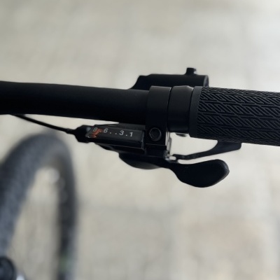 Punho de bicicleta com alavanca de mudança de velocidades e números visíveis no guidão preto